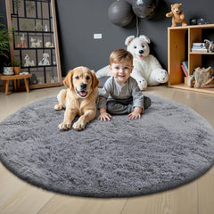 Child and dog on a gray round rug in a room with toys and decor.