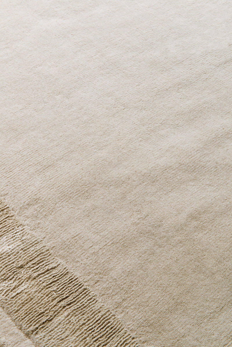 Close-up of Ashlar beige hand tufted wool rug surface