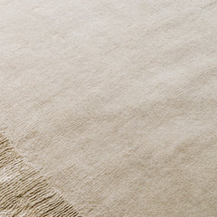 Close-up of Ashlar beige hand tufted wool rug surface