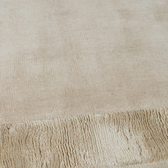 Close-up of Ashlar beige wool rug with bordered texture
