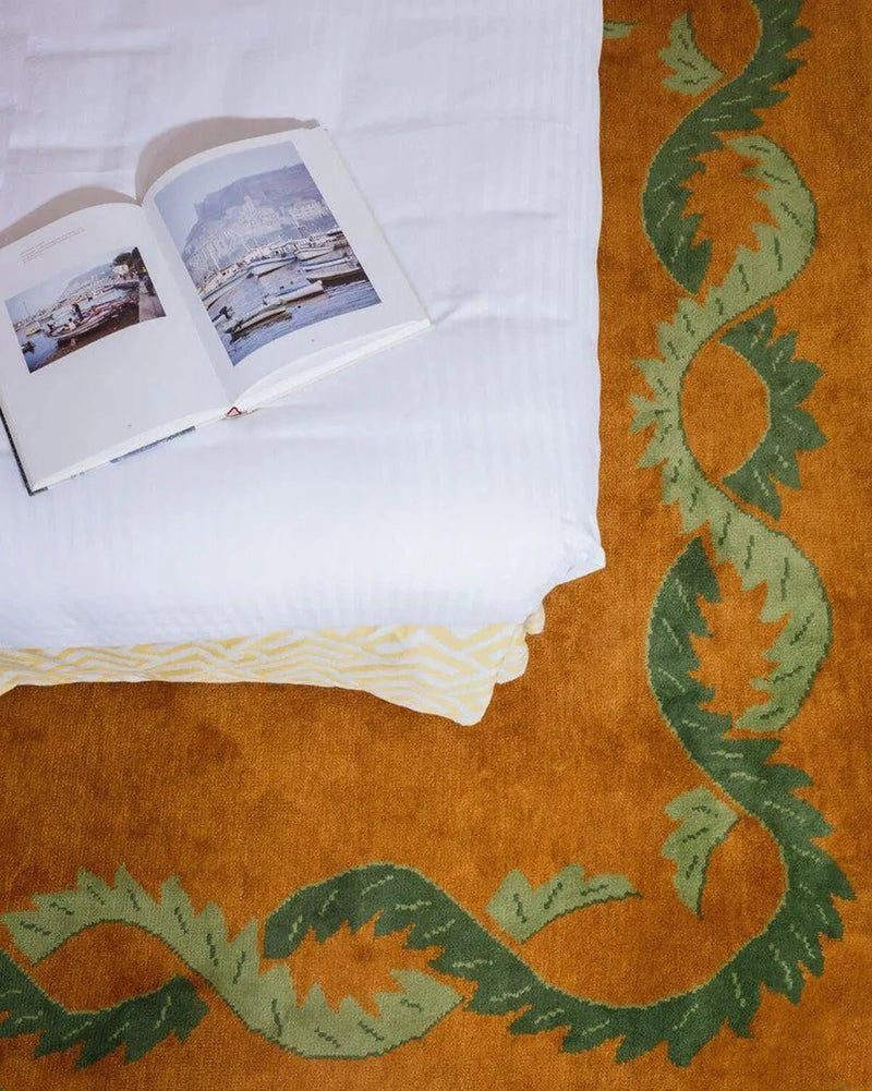 Coco orange floral border rug in a bedroom