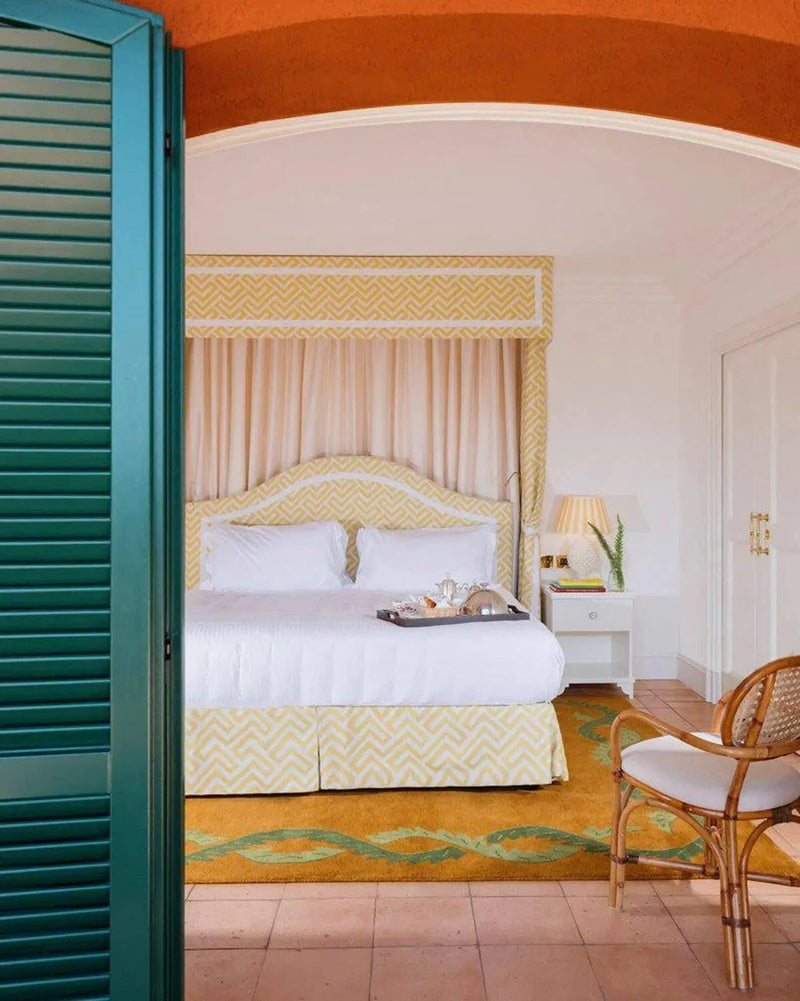 Coco orange and green floral wool rug in a bedroom