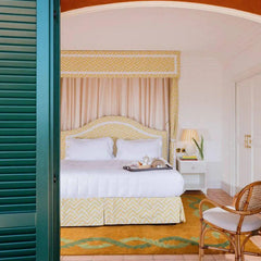 Coco orange and green floral wool rug in a bedroom